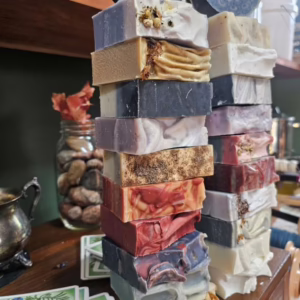 Two towers of soap, all different colors, scents, and herbs.